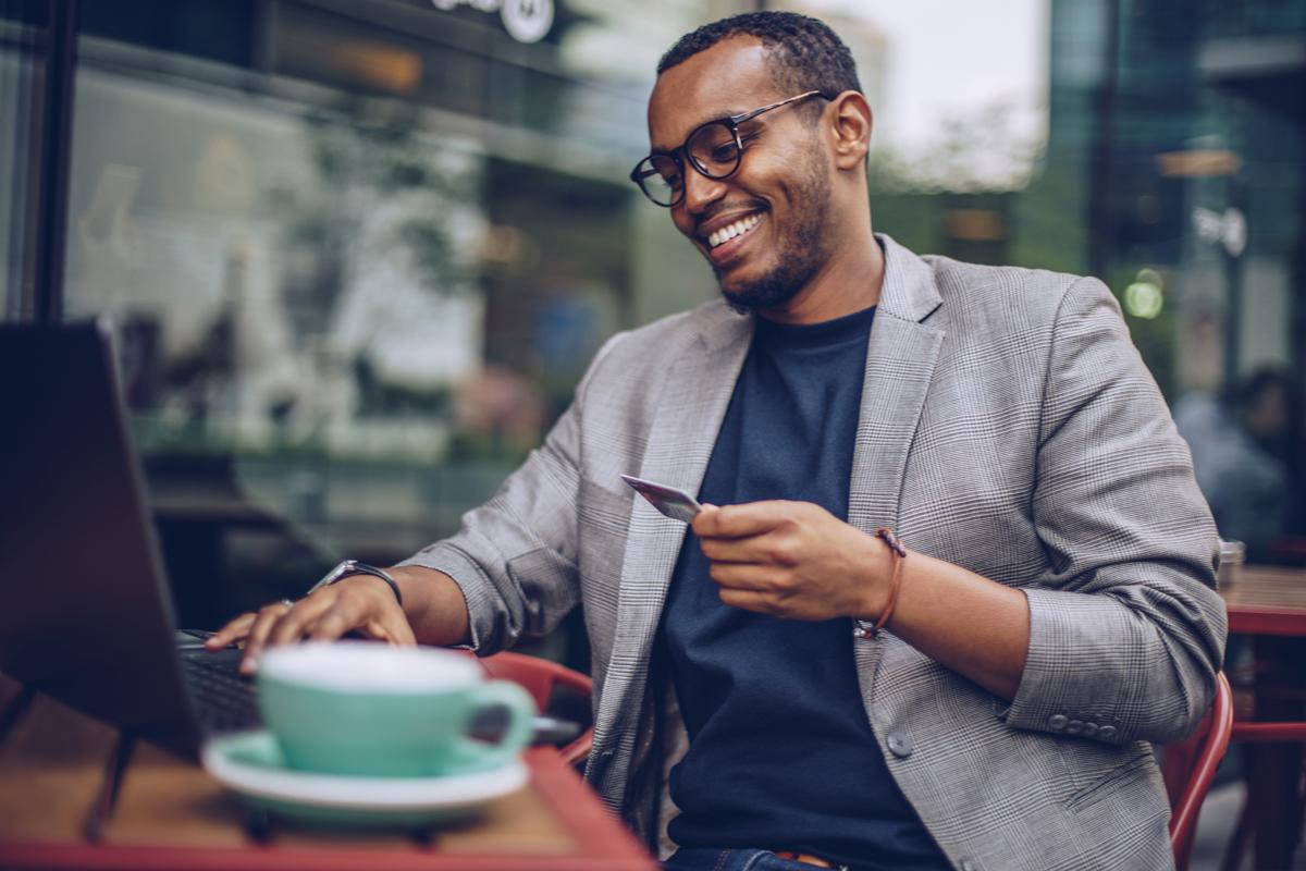 Man making an online purchase at a coffee shop.